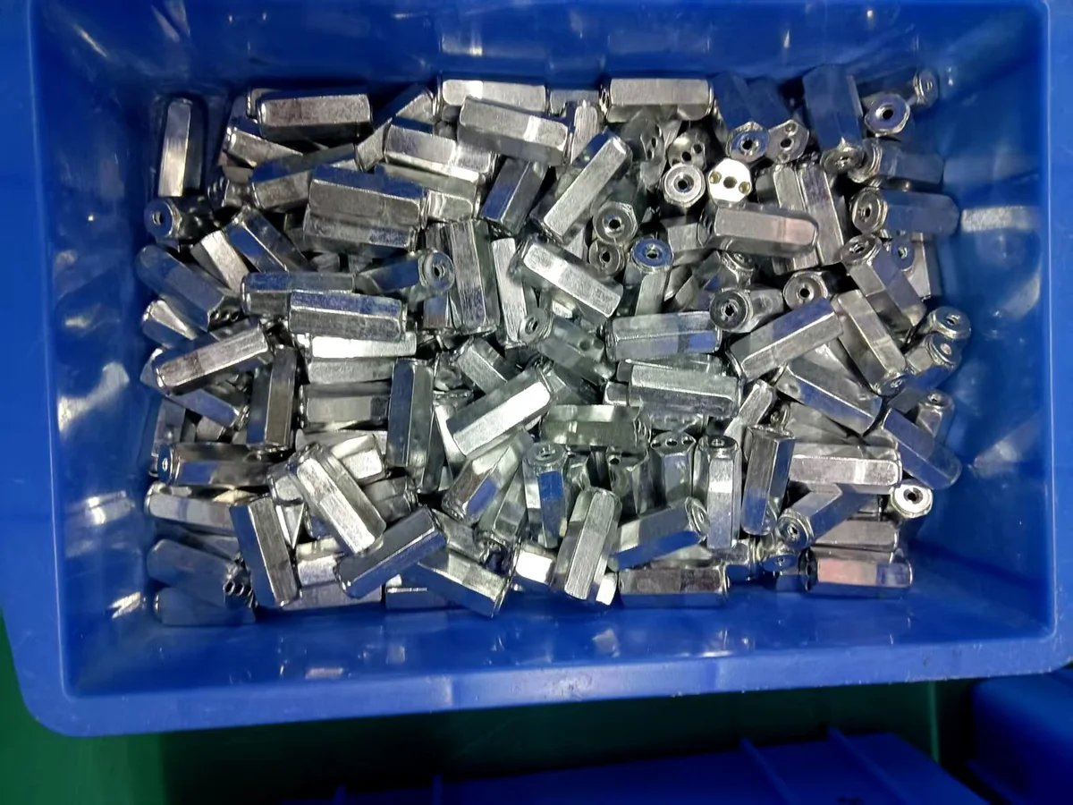Zinc-plated metal parts in a tray at incoming inspection